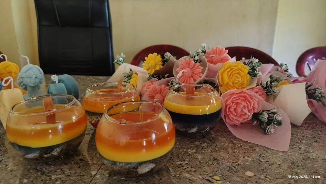 Finished candle bouquets in glass bowls, made by participants at a candle making training