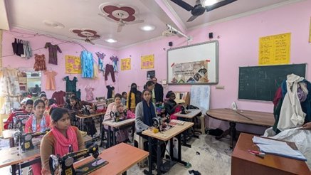 Women and girls at sewing machines during a vocational training session in Delhi