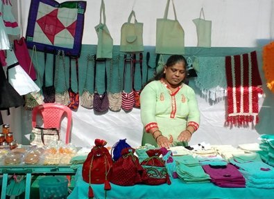 A woman selling SHG-made bags, pouches and accessories at a product display stall
