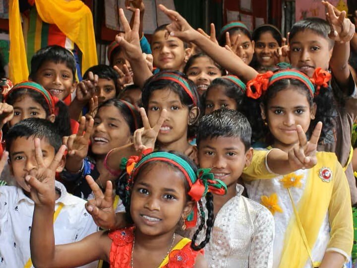 Schoolchildren celebrating together with peace signs in a classroom