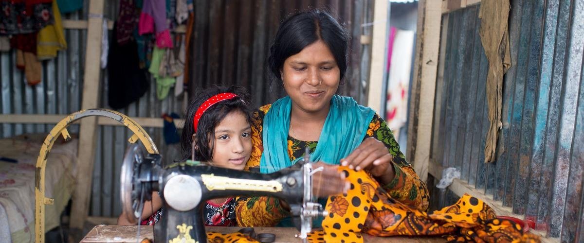 Mother and daughter working together at a sewing machine
